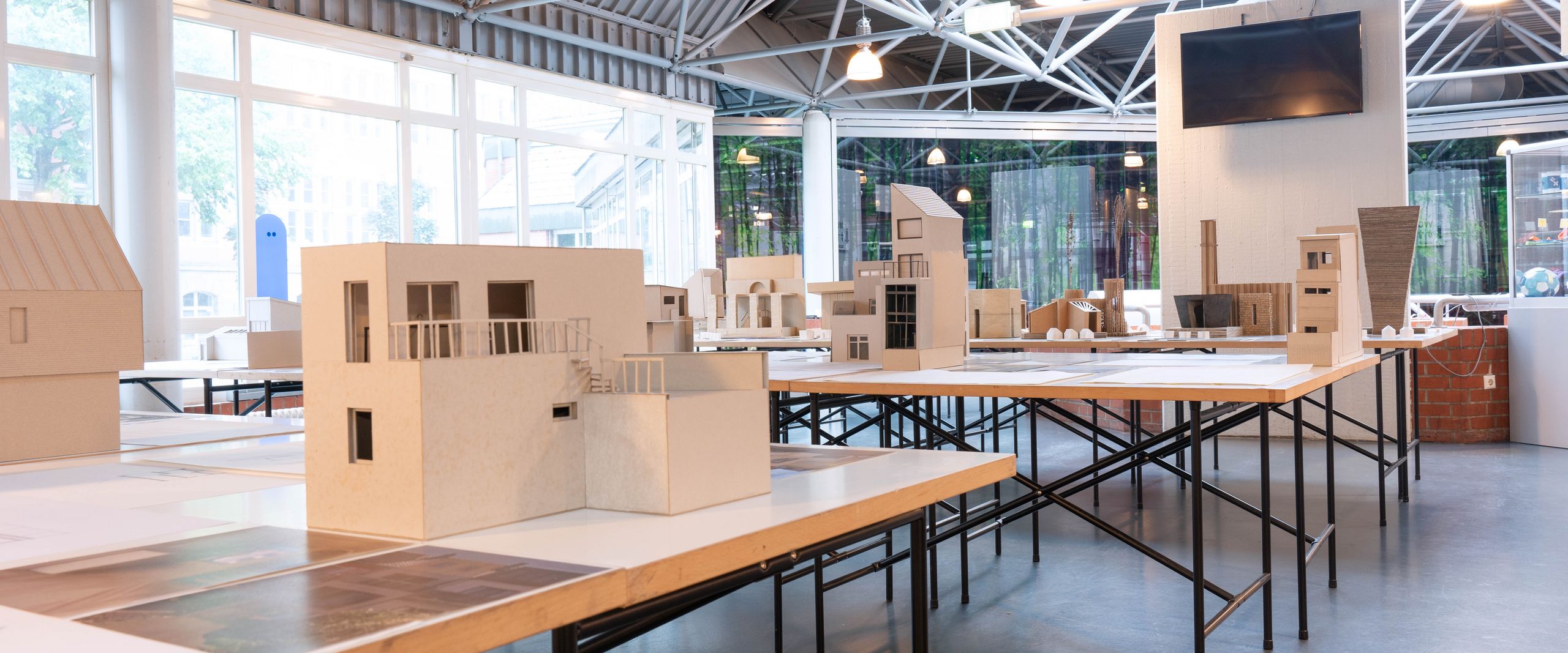 Architektur-Modelle stehen auf langen Tischen