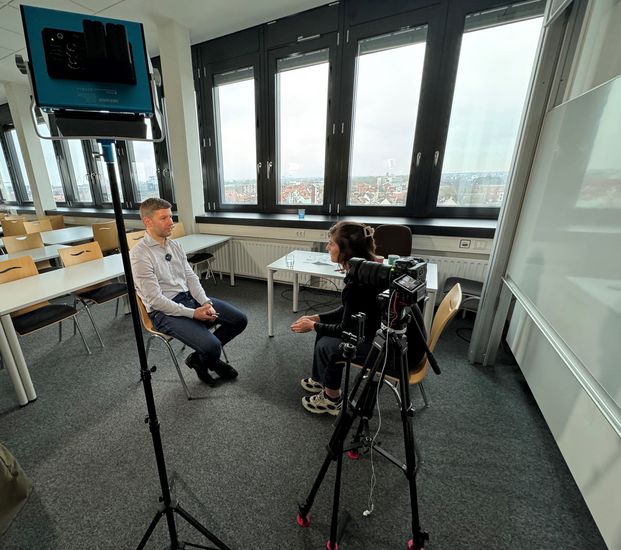 Mann und Frau im Seminarraum sitzen sich gegen&uuml;ber. 