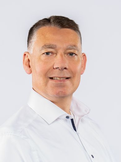 Auf dem Foto ist Hellmar Rockel zusehen. Er hat kurzes, schwarz-grau meliertes Haar und tr&auml;gt ein wei&szlig;es Hemd. 