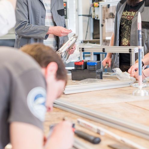 Studierende arbeiten an Bauteilen in einer Werkstatt