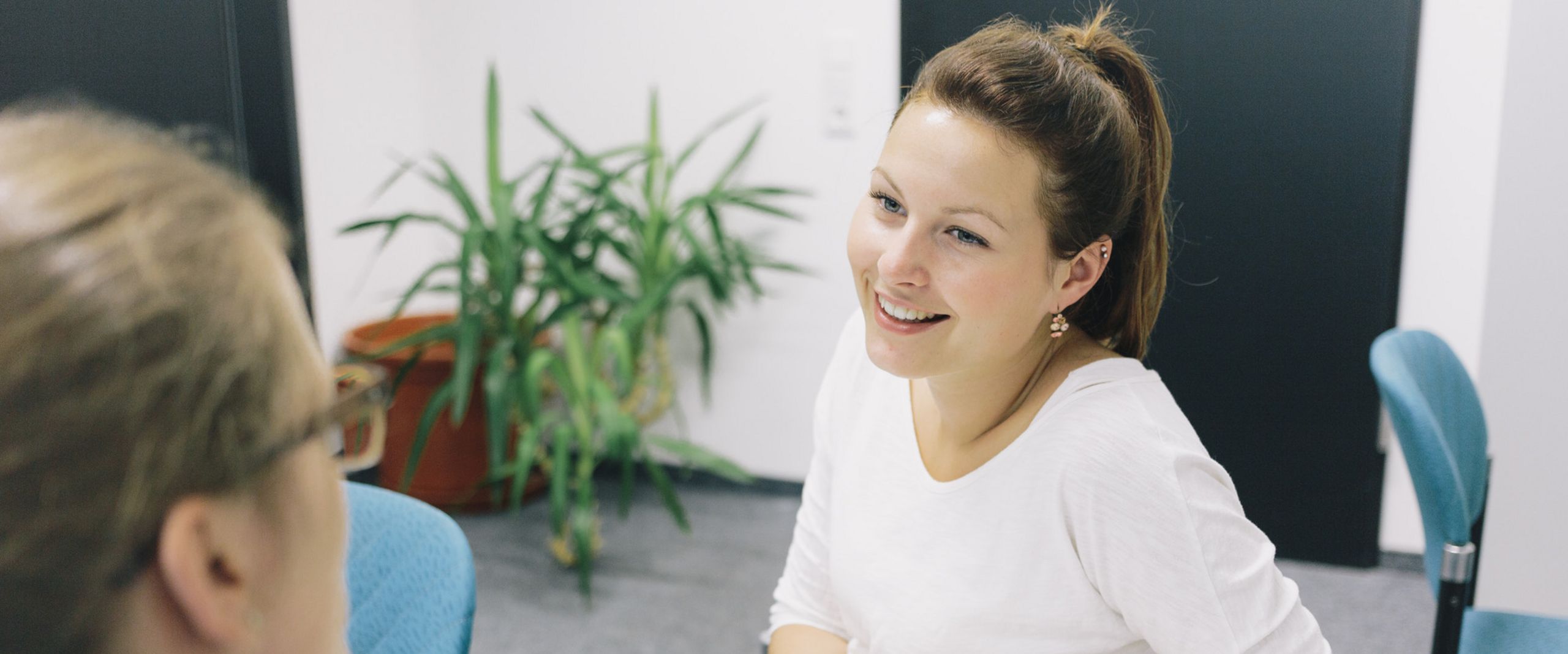 Eine Studentin und eine Studienberaterin sitzen sich an einem Tisch gegenüber.