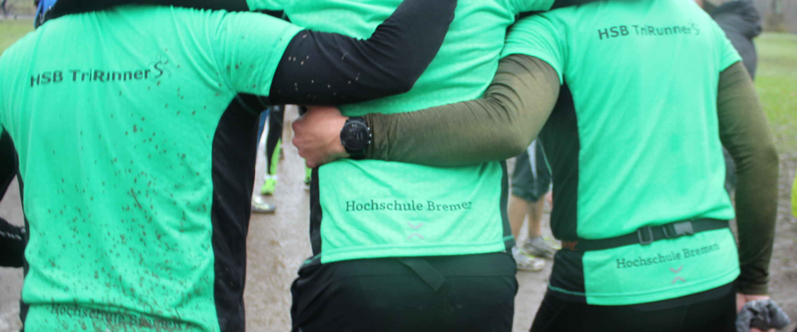 Drei L&auml;ufer sind der Kamera mit dem R&uuml;cken zugewandt und Tragen ein TriRunners Trikot.