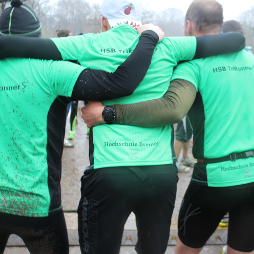 Drei L&auml;ufer sind der Kamera mit dem R&uuml;cken zugewandt und Tragen ein TriRunners Trikot.