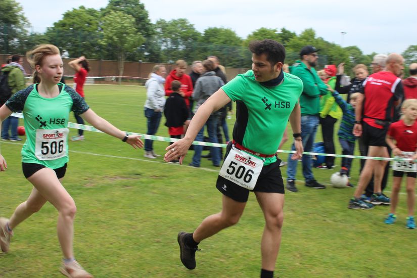 Zwei L&auml;ufer klatschen kurz vor dem Zielbogen ein.