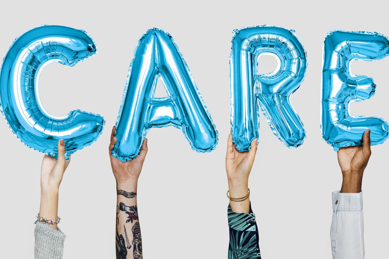 Care Hände, die die einzelnen Buchstaben des Wortes CARE hochhalten
