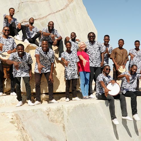Gruppe junger S&auml;nger aus Namibia auf Felsen zusammen mit ihrer Managerin Regine Hink