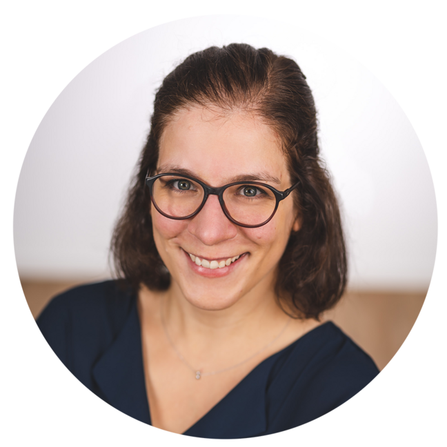 Porträt einer lächelnden jungen Frau mit schulterlangen braunen Haaren.