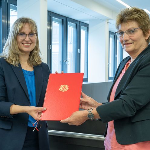 Frau Claus &uuml;bergibt Frau Lins eine Urkunde