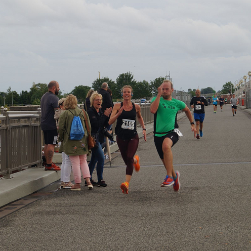 Zwei L&auml;ufer sprinten auf einer Br&uuml;cke.