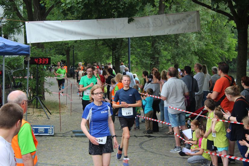 L&auml;ufer auf der Strecke und an der Seite stehen mehrere Zuschauer.