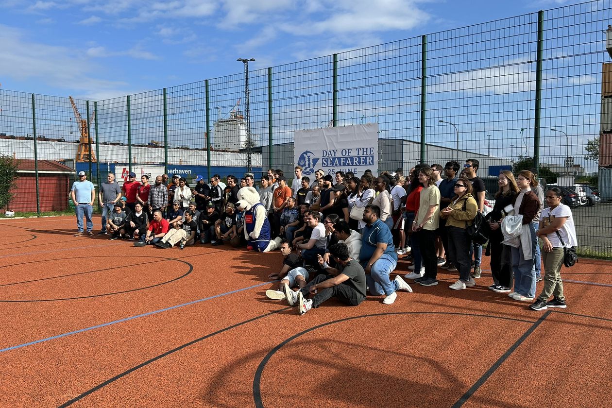 Gruppenfoto von Studierenden der HSB mit Seeleuten auf einem Basketballplatz.