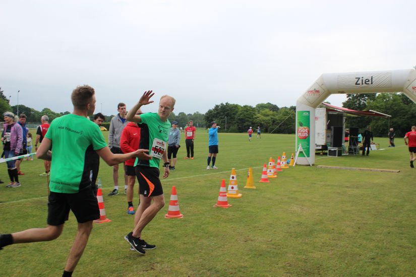 Zwei L&auml;ufer klatschen kurz vor dem Ziel ein.