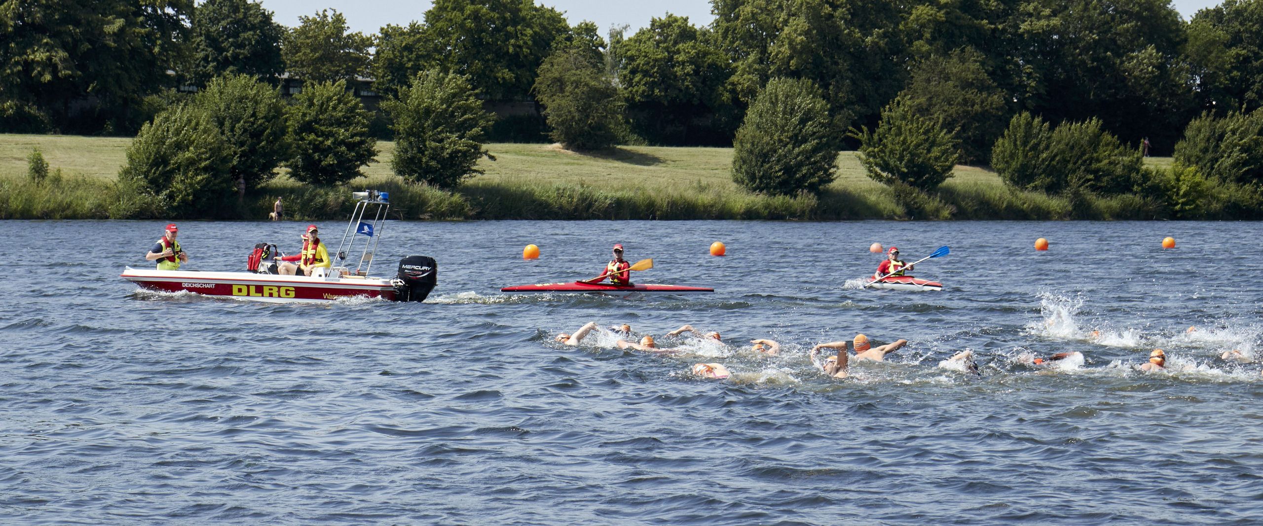 Werdersee mit Starterfeld von Duathlon 5. Swim&Run. Im Hintergrund sind DLRG Kajaks und ein Boot mit der Aufschrift "Deichschart" zu sehen.