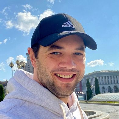 Auf dem Foto ist Christian Paluschkewitz zusehen. Seine Haare sind unter einer dunkelblauen Cap versteckt. Er hat einen leichten braunen Bart un tr&auml;gt einen grauen Kaputzenpullover. 