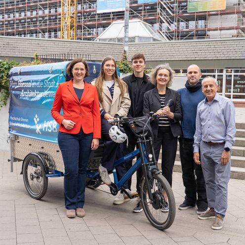 Gruppenbild mit M&auml;nnern und Frauen vor einem Lastenfahrrad. 