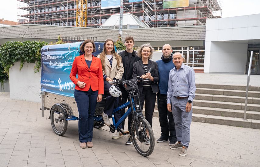 Gruppenbild mit M&auml;nnern und Frauen vor einem Lastenfahrrad. 