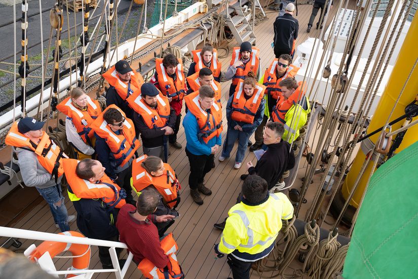 Studierende der HSB und Crew in Schwimmwesten an Deck auf dem Großsegler Alex-2