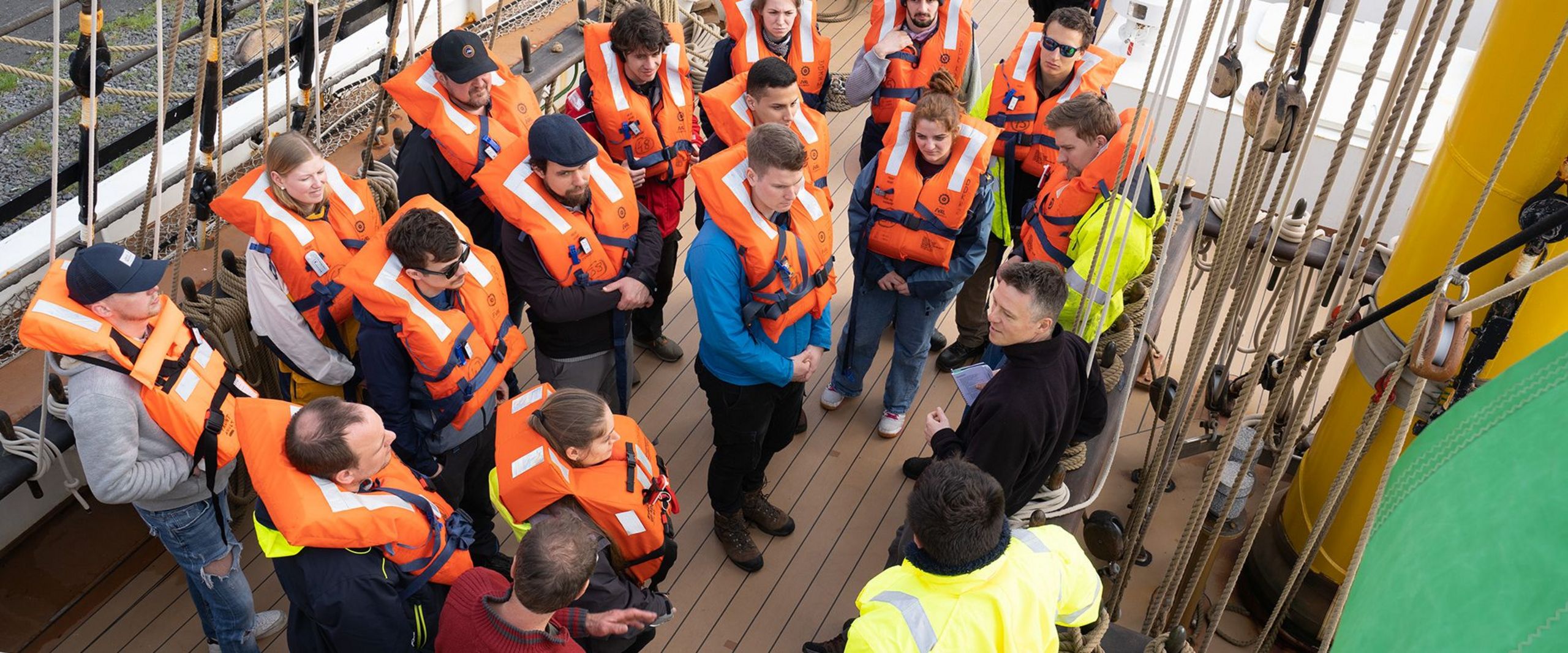 Studierende der HSB und Crew in Schwimmwesten an Deck auf dem Großsegler Alex-2