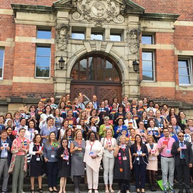 Zahlreiche Tagungsteilnehmer stehen vor dem Eingangsportal der HSB und halten jeweils die Flagge ihres Herkunftslandes in den Händen