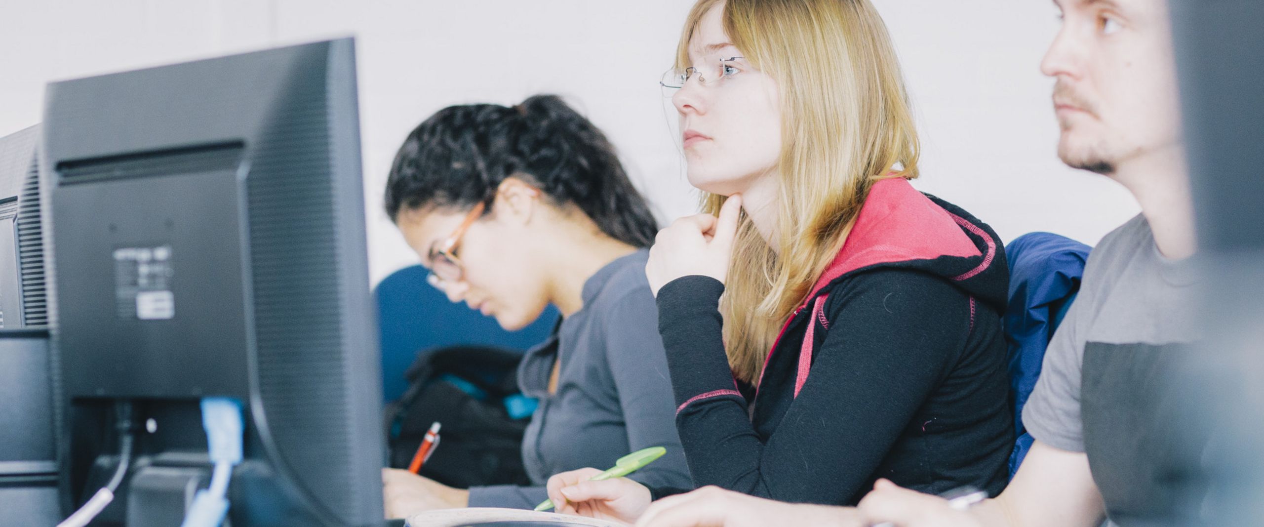 Studierende Drei Studierende arbeiten an Computern.