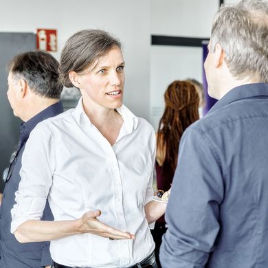 Lehrende unterhalten sich bei einer Feier der Fakultät Architektur, Bau und Umwelt.