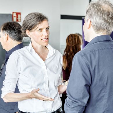 Lehrende unterhalten sich bei einer Feier der Fakultät Architektur, Bau und Umwelt.