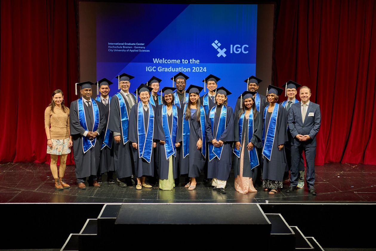 Gruppenbild mit M&auml;nnern und Frauen. Sie tragen Talare und H&uuml;te.
