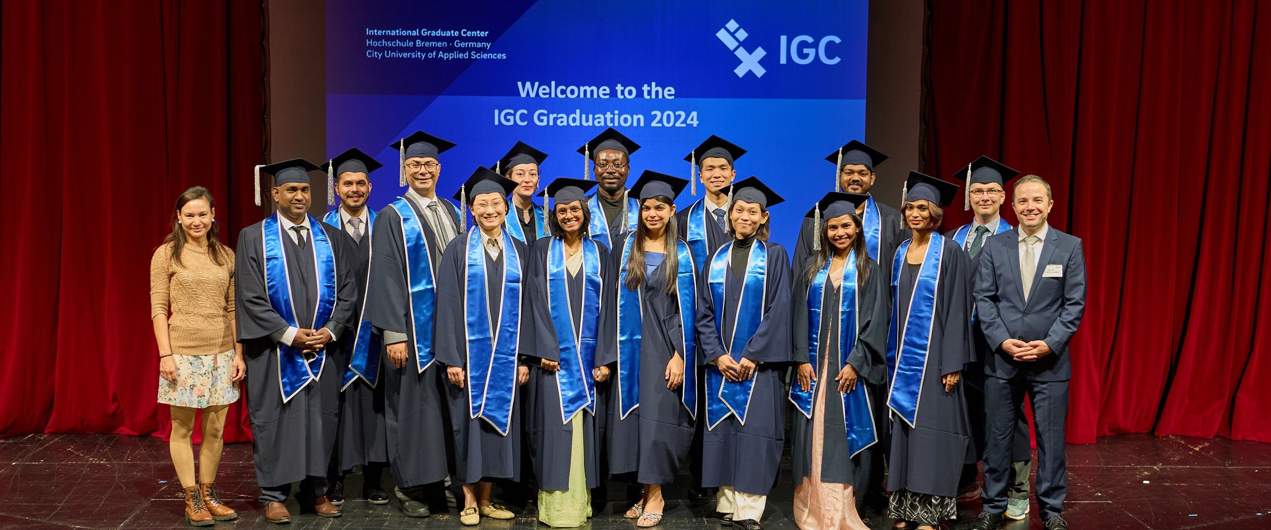 Gruppenbild mit M&auml;nnern und Frauen. Sie tragen Talare und H&uuml;te.