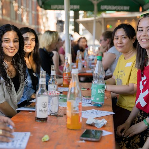 Eine Gruppe von Studentinnen der HSB sitzt an einem Tisch. Vor Ihnen stehen Getränke. Das Bild wurde aufgenommen an einem Sommerfest des MeetMINT Projekt an der HSB.