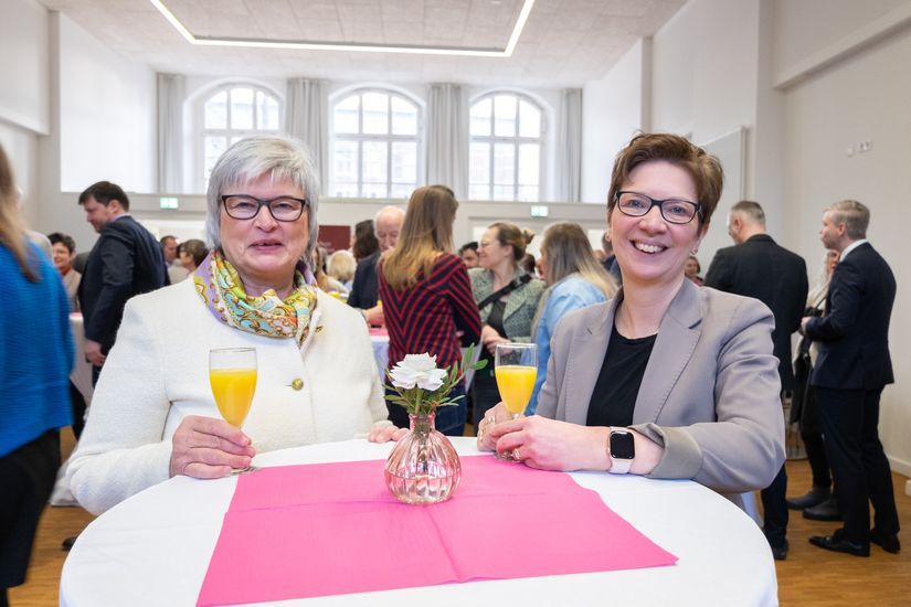 Zwei Frauen schauen l&auml;chelnd in die Kamera.