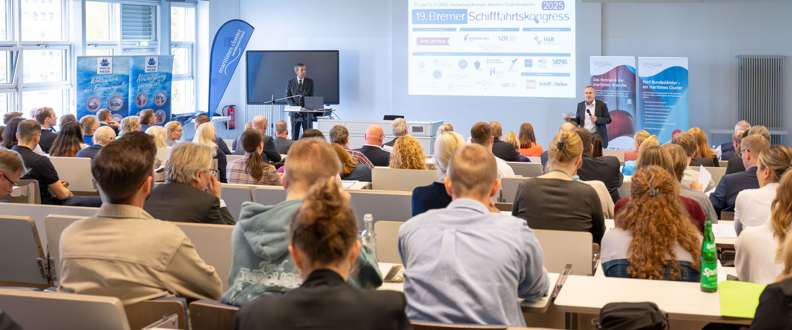 Prof. Bastian Gruschka steht in einem Vorlesungsraum im AIR-PORT-LAB vor einer Menge an Teilnehmenden am 19. Bremer Schifffahrtskongress_HSB