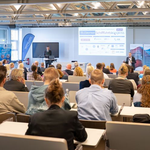 Prof. Bastian Gruschka steht in einem Vorlesungsraum im AIR-PORT-LAB vor einer Menge an Teilnehmenden am 19. Bremer Schifffahrtskongress_HSB