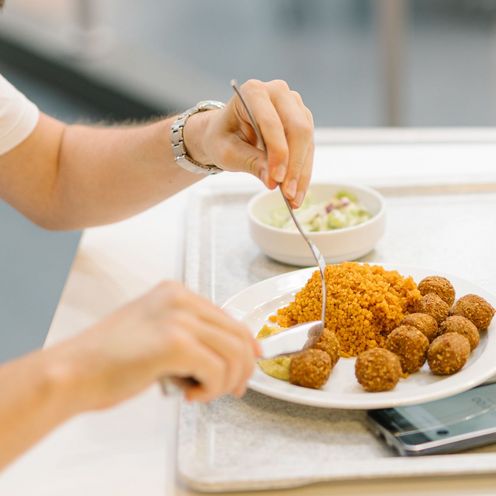 Mensagast beim Essen (Falafel)
