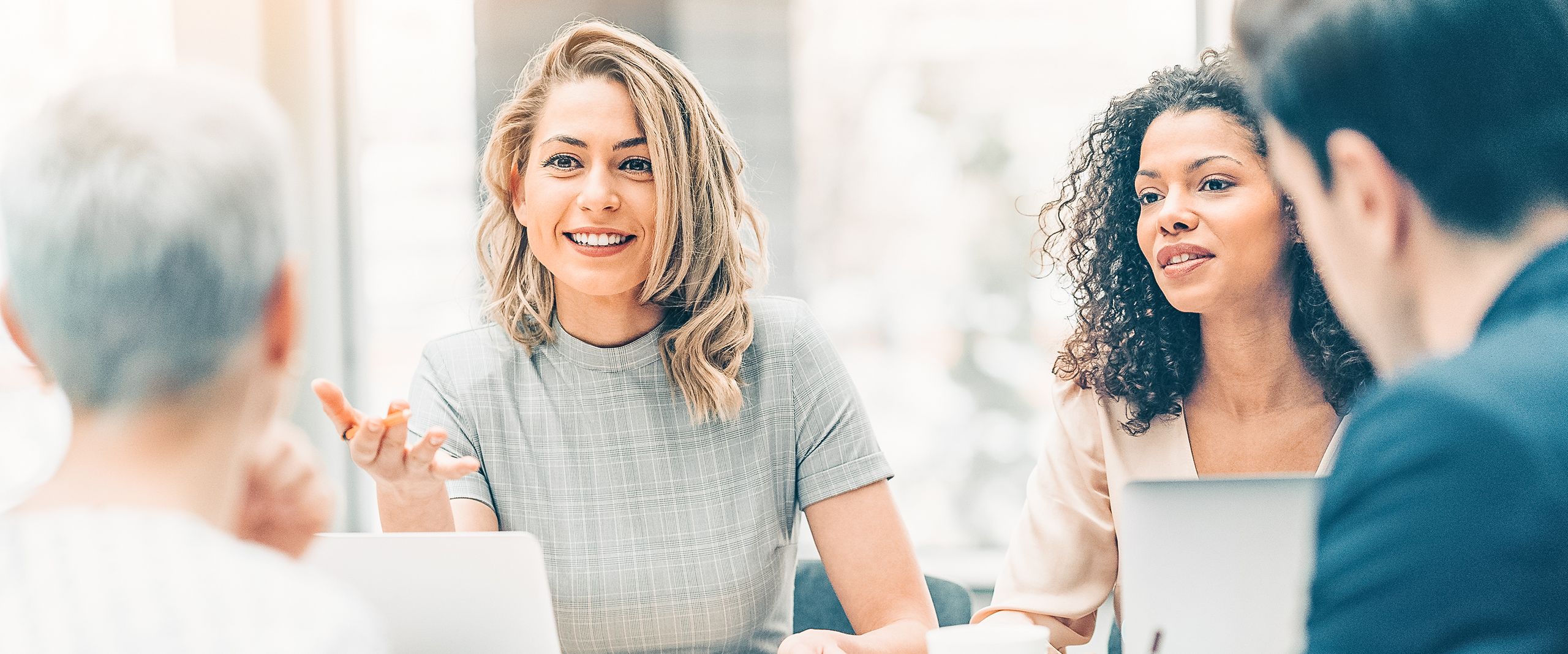 Vier Personen unterschiedlichen Alters und Nationalität unterhalten sich