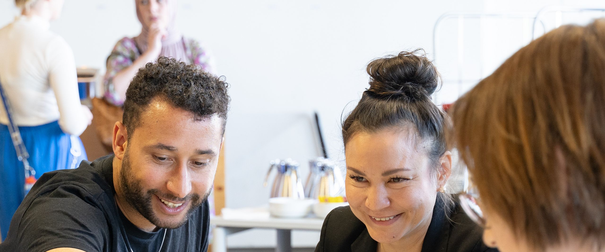 PM Diversity Café Mann und zwei frauen sitzen am Tisch und interagieren miteinander
