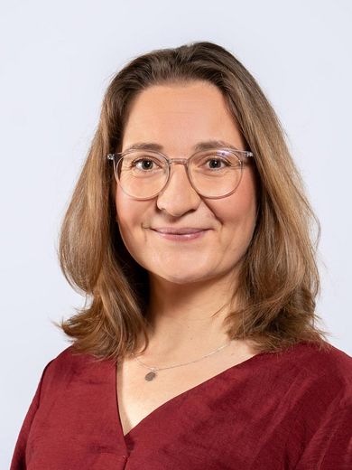 Auf dem Bild ist Carina Lehmann zusehen. Sie hat schulterlanges braunes Haar und tr&auml;gt eine dunkelrote Bluse.