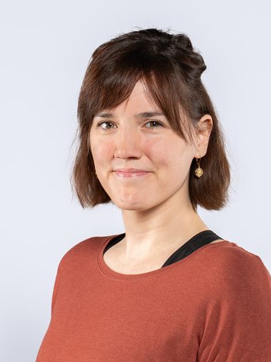 Auf dem Foto ist Indra Smith zusehen. Sie hat kinnlanges braunes Haar und einen Pony. Sie tr&auml;gt ein oranges T-Shirt. 