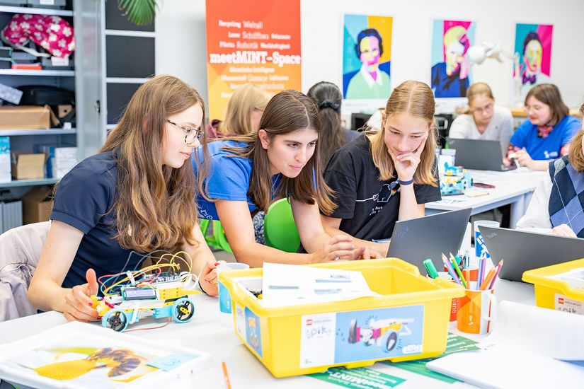Mehrere Sch&uuml;lerinnen im meetMINT-Lab programmieren und bauen mobile Roboter.