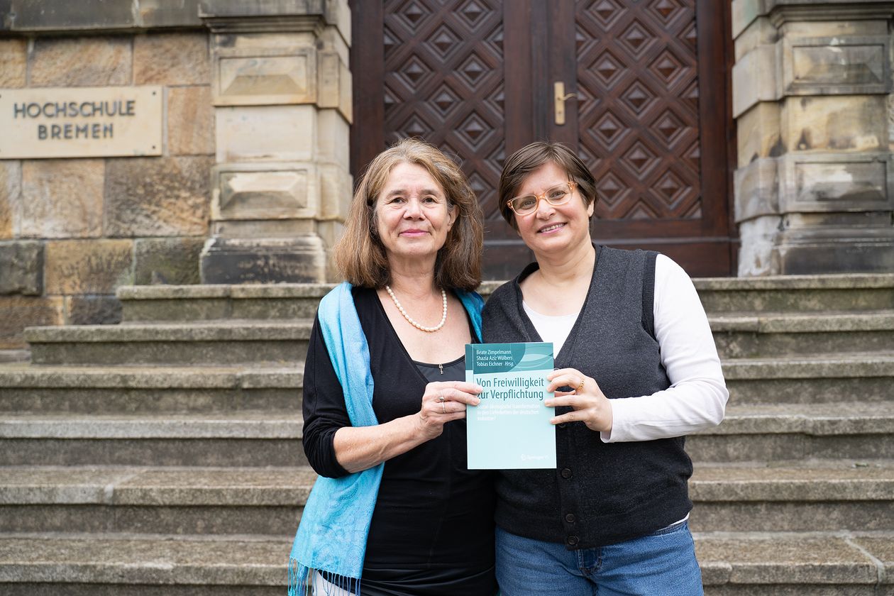 Die Professorinnen Zimpelmann und W&uuml;lbers pr&auml;sentieren ihr Buch "Von Freiwilligkeit zur Verpflichtung" vor dem M-Geb&auml;ude der HSB