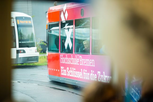 Zwei Wagen der Bremer Stra&szlig;enbahn, eine davon mit Logo der Hochschule Bremen.