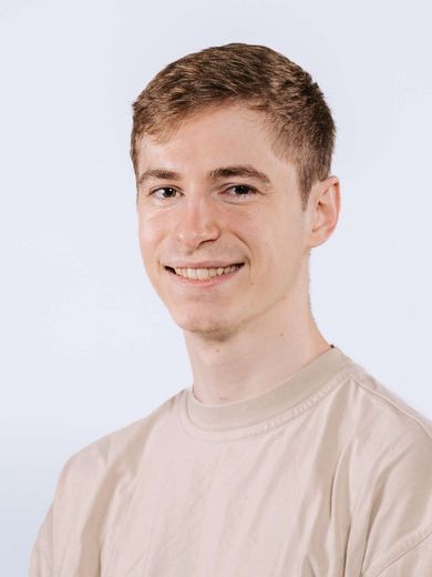 Auf dem Bild ist Jan Steinmüller zusehen. Er hat kurzes blondes Haar und trägt ein hellbeiges T-Shirt. 