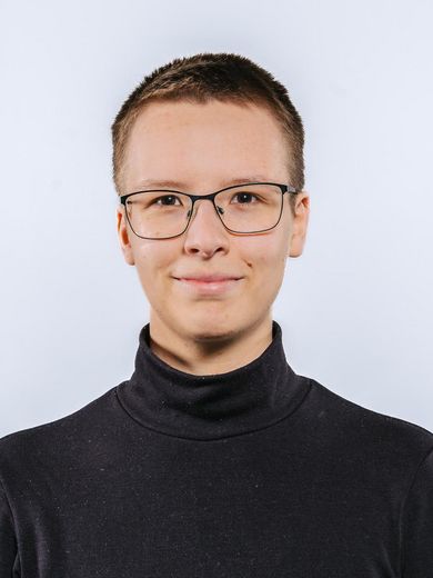 Auf dem Bild ist Kim Wagner zusehen. Sie hat sehr kurzes, dunkelblondes Haar und trägt eine Brille und einen schwarzen Rollkragenpullover. 