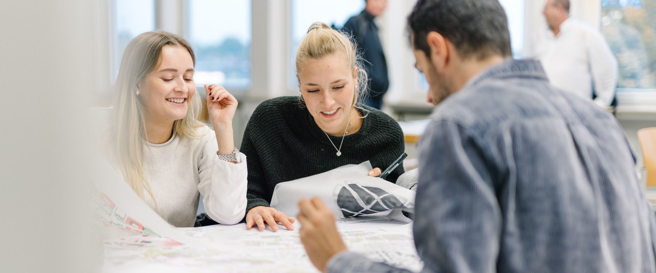 Workshop Urban Cities Studierende sitzen bei einer Gruppenarbeit an einem Tisch.