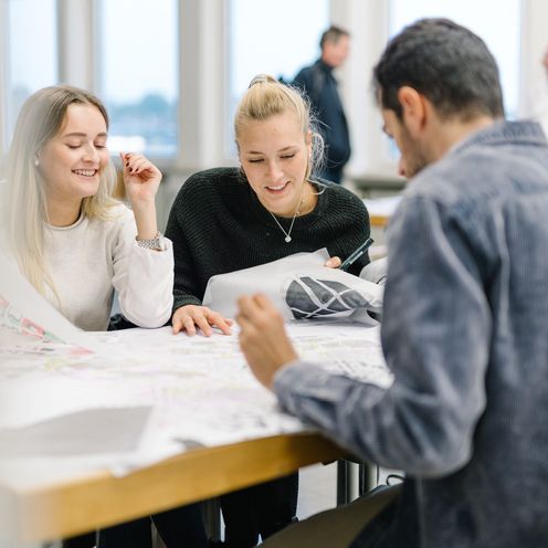 Studierende sitzen bei einer Gruppenarbeit an einem Tisch.