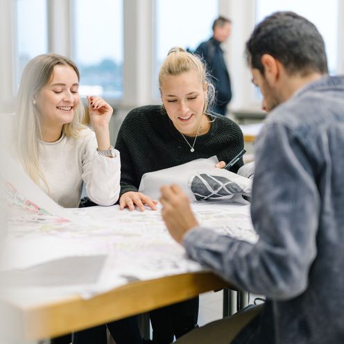 Studierende sitzen bei einer Gruppenarbeit an einem Tisch.
