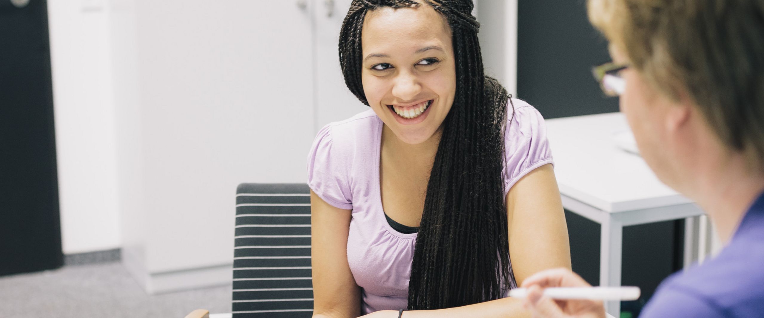 Studienberatung Eine Studentin und ein Studienberater sitzen sich an einem Tisch gegenüber.