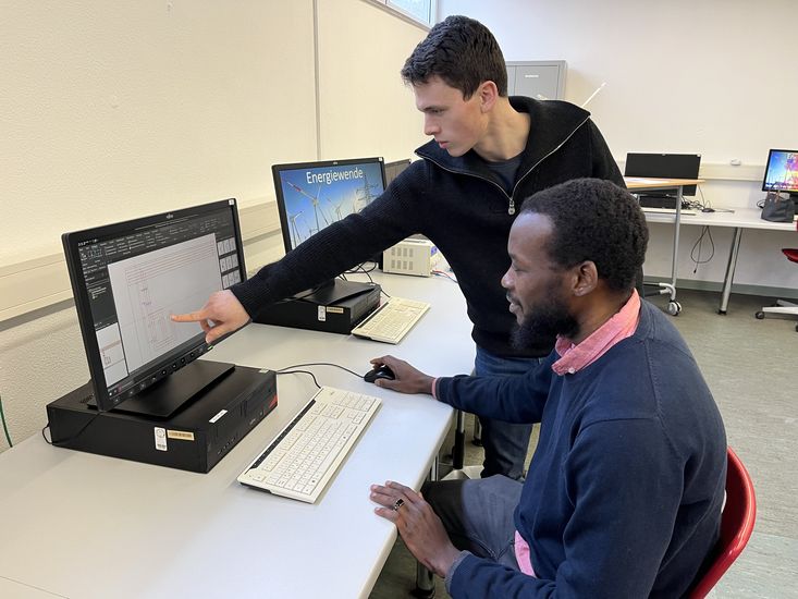Ein Lehrer zeigt einem Sch&uuml;ler etwas auf einem PC
