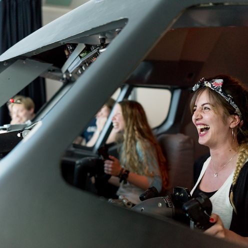 Studierende lachend im Flugsimulator.
