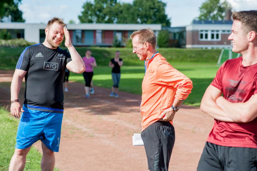 Läufer stehen an der Strecke und unterhalten sich.