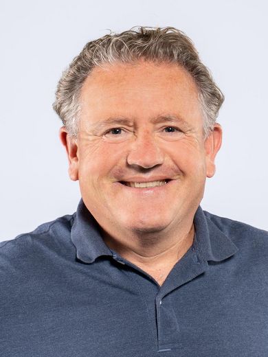 Auf dem Foto ist Jeremy Hookway zusehen. Er hat graues lockiges Haar und tr&auml;gt ein dunkelblaues Polo-Shirt.